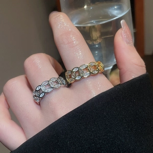 Detail of 18k gold plated open ring with sparkling zircon circles on a female finger