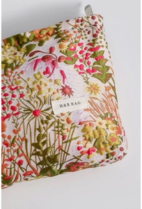 Close-up of vintage floral jacquard fabric texture and brand label on makeup bag