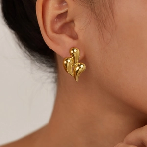 Polished gold-plated stainless steel teardrop earrings worn by a fashion model