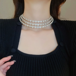 Close-up of a three-row silver choker necklace with rhinestones on a female model