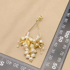 Boucles d'oreilles vintage en perles dorées avec feuilles sur fond de tissu