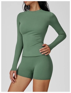 Detail of sage green brushed fabric on long-sleeve yoga top and high-waist shorts set