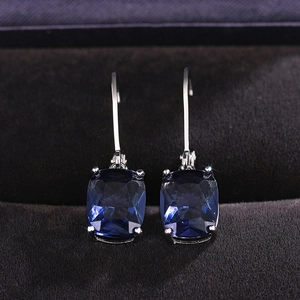 Macro shot of Radiant cut blue topaz cubic zirconia earrings with silver hooks in a gift box