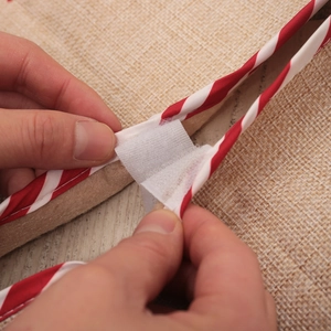 Linen Christmas tree skirt with red and white striped borders and Velcro closure