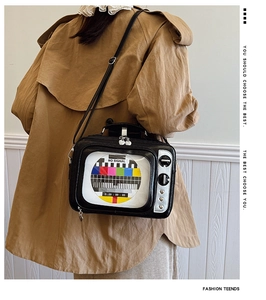 Detail of retro TV shaped crossbody bag with No Signal screen pattern and heart studs