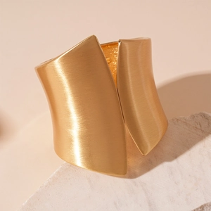 Detail of matte gold irregular geometric cuff bracelet with brushed metal texture