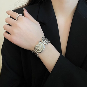 Macro shot of silver-plated starfish nautilus cuff bracelet with textured spiral details