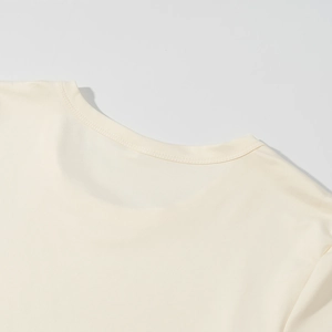 Vista dettagliata delle cuciture dello scollo di una maglia in maglina color bianco crema
