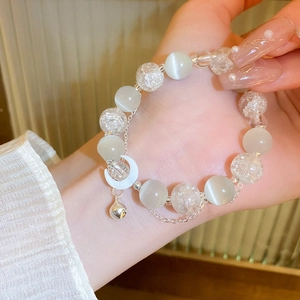 Detailed shot of moon pendant and white opal beads on a multi-layer beaded bracelet
