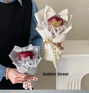 Detail of Christmas apple bouquet with lace trim, glitter wrap, and snowflake plug-in