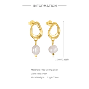 Close-up of 925 sterling silver earrings with irregular gold pendants and white pearls
