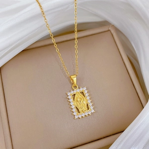 Detail of gold portrait frame pendant with religious relief and sparkling zircon border