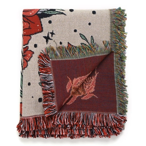 Detailed close-up of bohemian knit blanket with floral patterns and colorful fringe edge