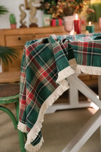 Dettaglio tovaglia a quadri scozzesi rossi e verdi con nappe decorative bianche