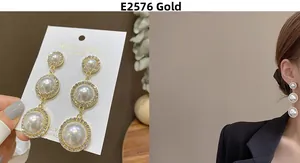 Detailed close-up of triple-layered pearl drop earrings with sparkling zircon halos and gold base