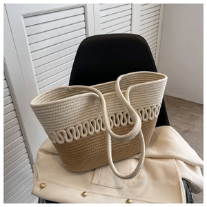 Detail of beige and camel color-block woven tote bag resting on a black chair