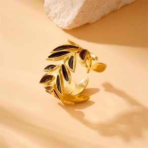 Vintage gold-plated stainless steel ring with black leaf design on a stone base