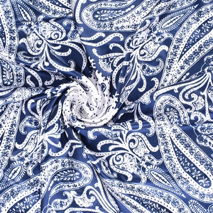 Detail of blue and white paisley pattern satin silk scarf with elegant spiral folding