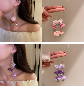 Detail of floral tassel earrings featuring pink fabric petals and purple crystal drops