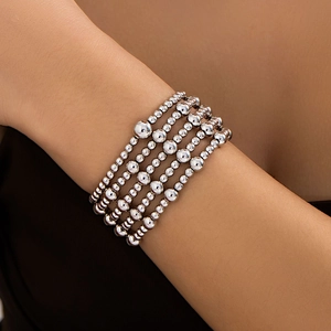 Close-up of multilayer silver beaded bracelet set with varying bead sizes on model arm