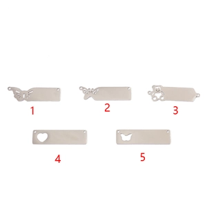 Close-up of DIY stainless steel tags with butterfly, bear, and heart cutouts