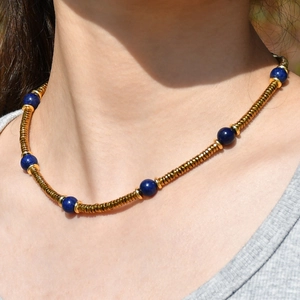Detail of colorful tourmaline necklace with gold spiral tubes on model neck