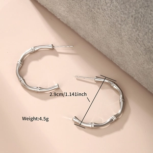 Detail view of silver bamboo-style C-shaped earrings with size 2.9cm and weight 4.5g