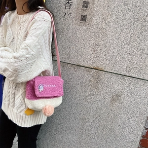 Detail of pink fleece crossbody bag with OZAKKA embroidery and cartoon astronaut patch