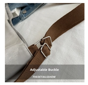 Close-up of adjustable metal buckles and woven shoulder strap on a canvas tote bag