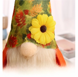 Detail of harvest gnome featuring maple leaf pattern hat and yellow sunflower decor