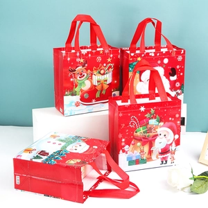 Detail view of four red non-woven Christmas gift bags with various festive prints