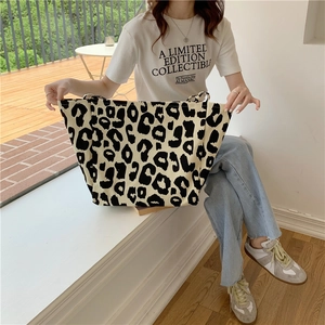 Lifestyle view of large leopard print canvas tote bag held by model in natural light