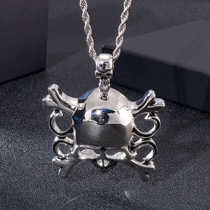 Detail of silver skull and crossbones pendant with twisted rope chain on dark background
