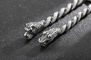 Close-up of punk style stainless steel bracelet featuring tiger and dragon head carvings