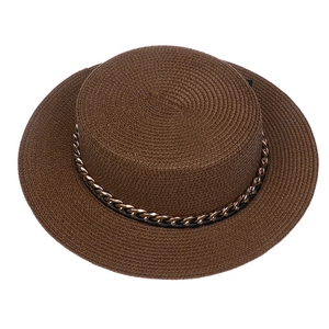 Close-up of brown straw hat featuring woven texture and gold metal chain detail