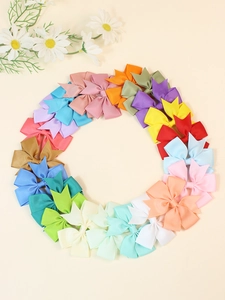 Overhead view of colorful 8cm ribbon bow hair clips arranged in a circle on beige surface