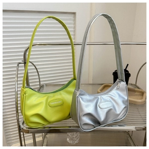 Detail view of stylish pleated underarm bags in silver and neon green PU leather