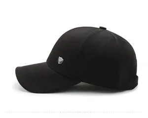 Side view of black baseball cap with fine texture and silver shield metal emblem