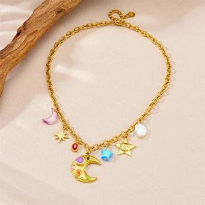 Gold chain necklace with moon, star and colorful stone pendants on sandy background