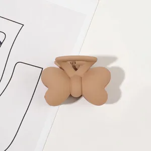 Close-up of a matte khaki butterfly hair claw clip on a minimalist white background