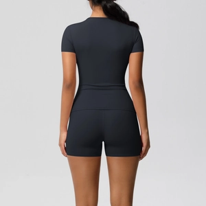 Rear view of sleek black high-elastic athletic set with short sleeve top and tight yoga shorts
