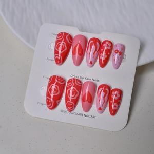 Detailed view of red and pink Y2K press-on nails with heart, cherry, and flame patterns