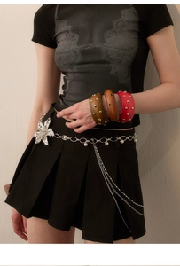 Detail of vintage wooden bangles with metal studs and silver floral pearl waist chain