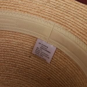 Vista interna del cappello in rafia che mostra la trama naturale e l'etichetta