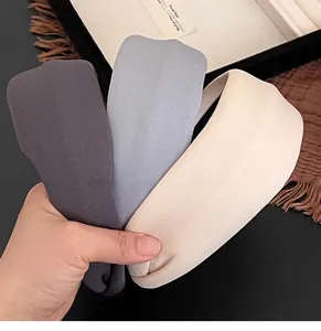 Close-up of three-color knitted wide headbands in grey, blue-grey, and beige tones