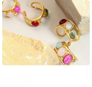 Detailed top view of retro gold rings featuring colorful oval stones on natural rocks