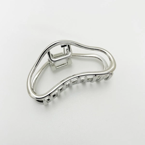 Close-up of sleek silver alloy hair claw clip with modern minimalist linear design