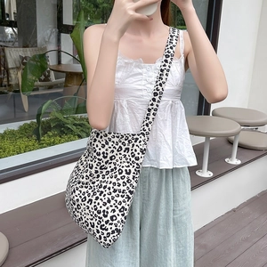 Detailed view of the large capacity leopard print canvas crossbody bag on a model