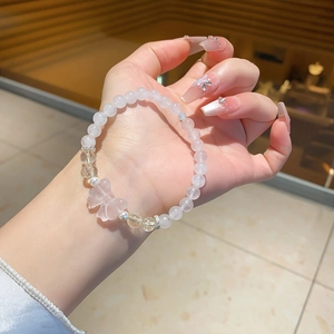 Detail of beaded chalcedony bracelet with pink crystal butterfly pendant on wrist