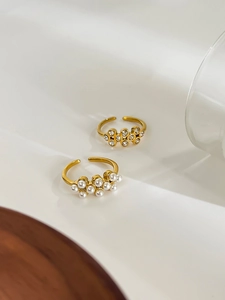 Detail of 18k gold plated adjustable rings with pearls and zircon flower cluster